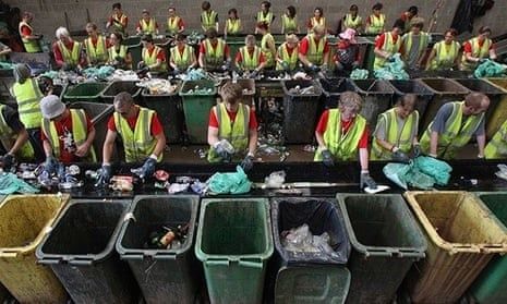 Volunteers sort festival waste into rows of recycling bins