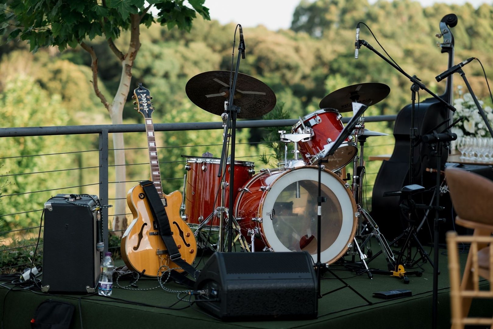 Outdoor stage with drum kit, guitar, microphones, and amplifiers